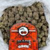 Close-up of Cherry Gushers cannabis strain – dense, frosty buds with vibrant green and orange hairs